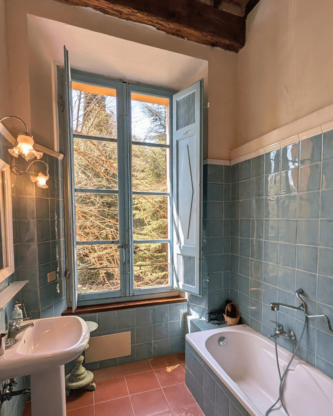 An ensuite bathroom with French windows over the grounds